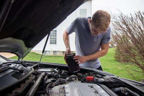 Senior Jake Dederer removes his cold air intake to clean it while self-quarantined at home.