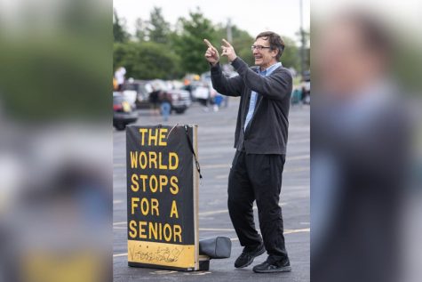 Retiree Paul Krull. math teacher, congratulates the Class of 2020 at their Farewell Parade on May 21. He displayed his infamous