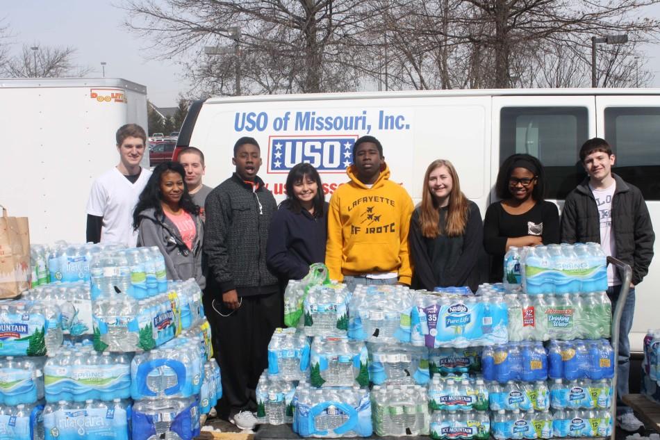 Air Force Junior Reserved Officer Training Corps students stand with water bottles donated.  March 5 saw an extensive operation carried out, as water was moved from throughout the building to United Service Operation (USO) vans. 