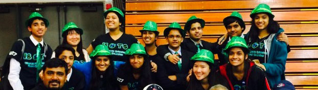 iBots team 6127 smiles in their signature green hats after a competition. The team builds 18x18x18 robots to compete in obstacle courses.