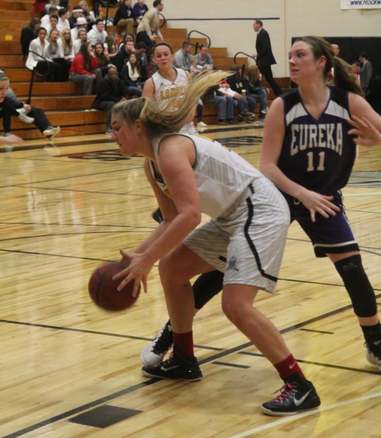 Maria Johnson dribbles the ball and drives to the hoop.