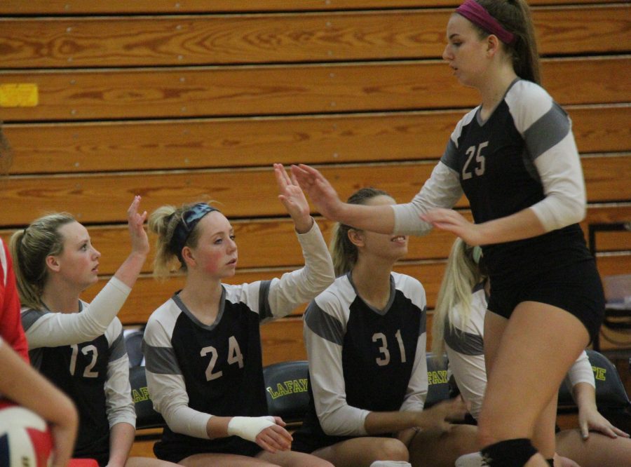 Hannah Flowers (25) high-fives her teammates as she comes to the bench.