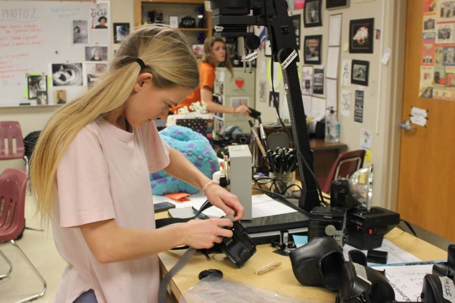 Learning how to use the new cameras, senior Millie Schofield practices loading film cartridges in Photography 1. “I like photography because in the projects I am able to show my personality through the photos I shoot and it’s easy to incorporate things that I’m interested in into my projects,” Schofield said.