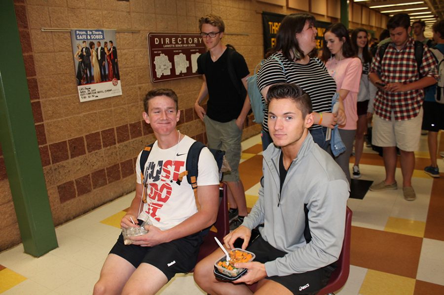 Because of the length of the prom ticket lines, seniors Wade Stauss and Conner Keithly pull up chairs to eat lunch during the wait.