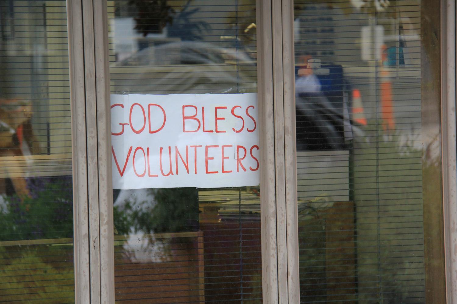 A sign reading God Bless Volunteers is posted in a window along South Central Avenue to show appreciation for the help provided by volunteers over the past several days.