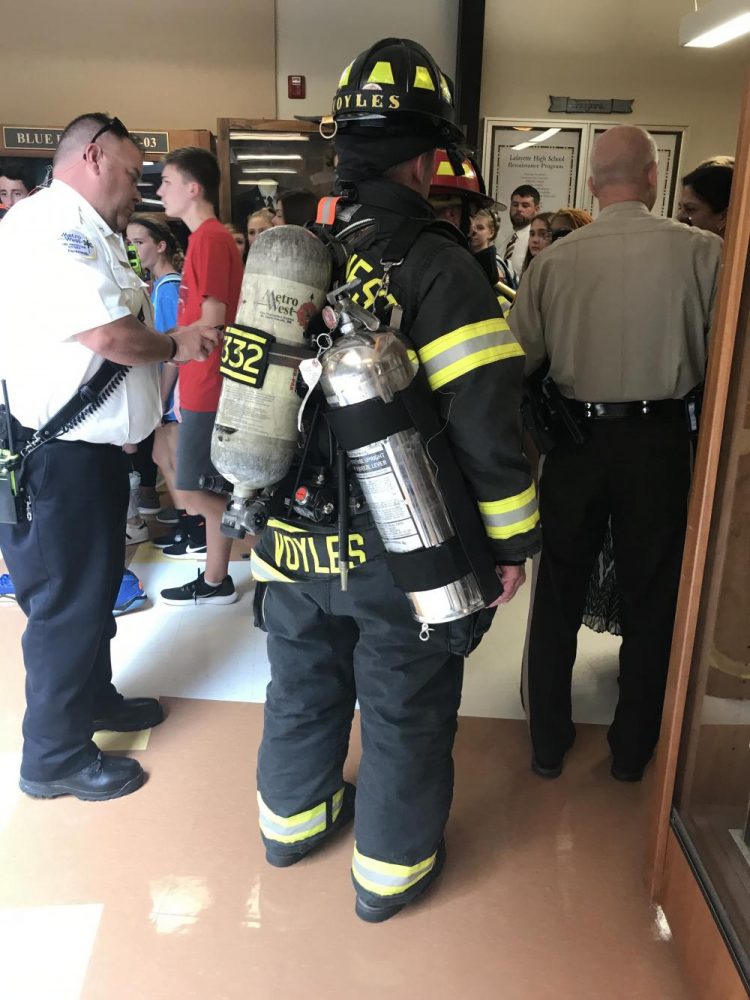 Firemen exit the building after confirming that the alarm was only a faulty smoke detector.