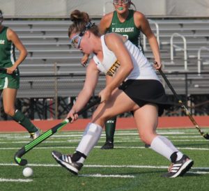 Running past her defenders, senior Meghan Conroy looks for an opportunity to score. Conroy was a big part of the field hockey teams success, scoring a total of 26 goals.  