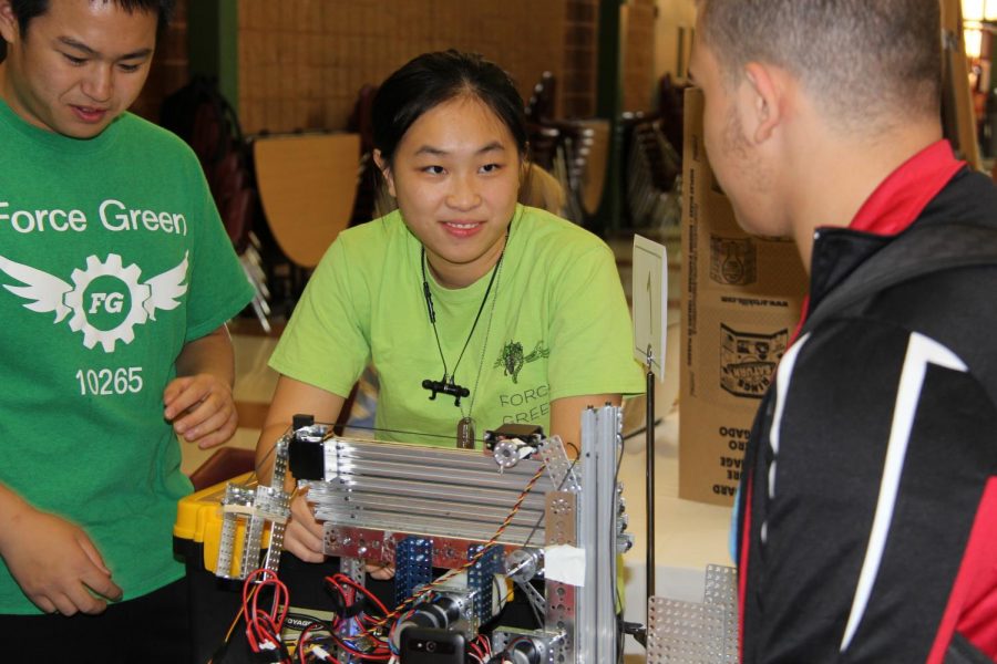 At the Lafayette Robotics table, Emily Liu, junior, shows off a robot to visitors as they stop by.