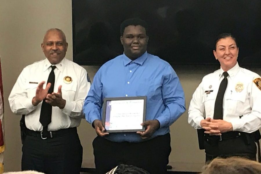 Sims standing with two other police officers receiving his Do the Right Thing Award. 