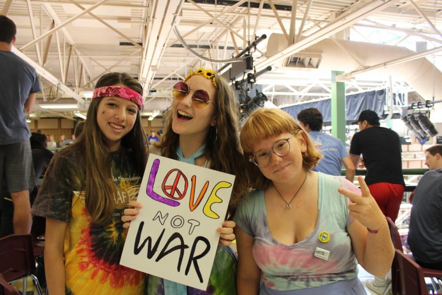 Holding the Love Not War sign,  juniors Alyah de Ugarte, Kaitlyn Barefield and Jenny Benton dressed up in tie dyed outfits to remember the hippies of the 1960s. 