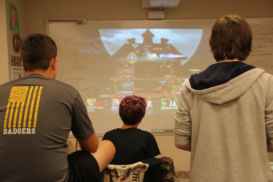 Members of the Video Game Club gather around a whiteboard to play Super Smash Bros., a popular Nintendo game. 
