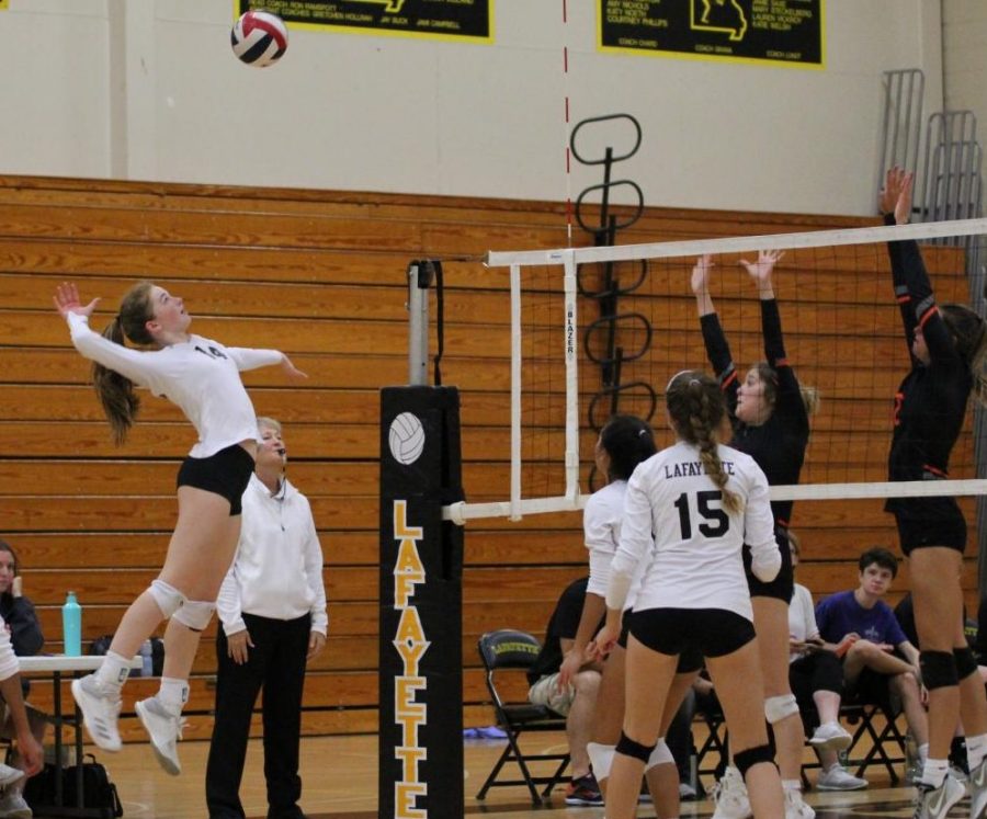 During the Sept. 11 girls volleyball game against Webster Groves, junior Brooke Borgmeyer hits a set from sophomore Jenny Nguyen. Borgmeyer had eight kills in the Lancers two set victory over the Statesmen. At the conclusion of this week, the girls volleyball team has an overall record of eight wins and three losses. 