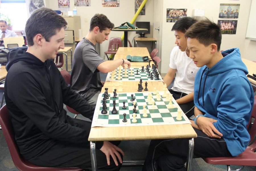 The members of the chess club play chess and forms strategies to win the game.
