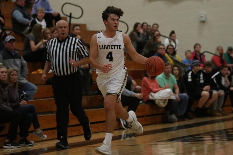 During the Dec. 4 boys basketball game against Parkway Central, senior Jack Schmitt pushes the ball up the court. Schmitt had 21 points in the 65-55 Lancer victory. 