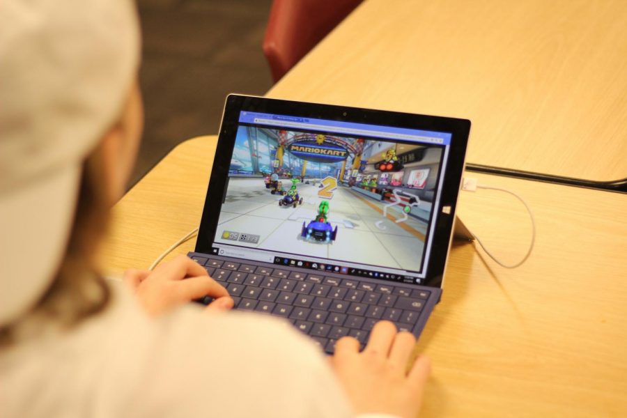 On his laptop in a classroom, senior Carson Luther plays Mario Kart. With the addition of Flex Time this year, various students have chose to spend their time in the Library playing video games, but a new library policy has impacted those students. 