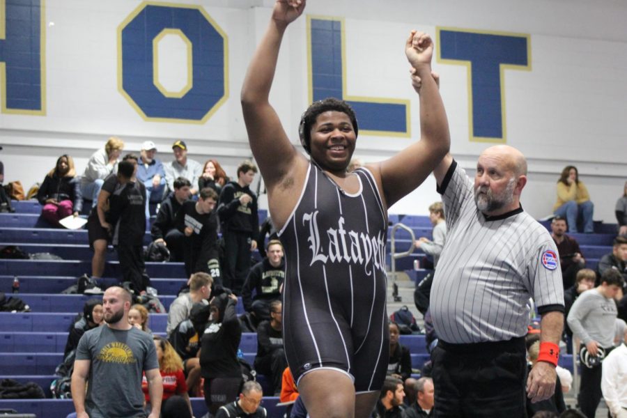 After defeating his opponent in the Holt Quad on Dec. 4, junior Anthony McRoberts celebrates. This week on Dec. 16, McRoberts pinned his opponent to seal the Lancers victory over Lindbergh. 