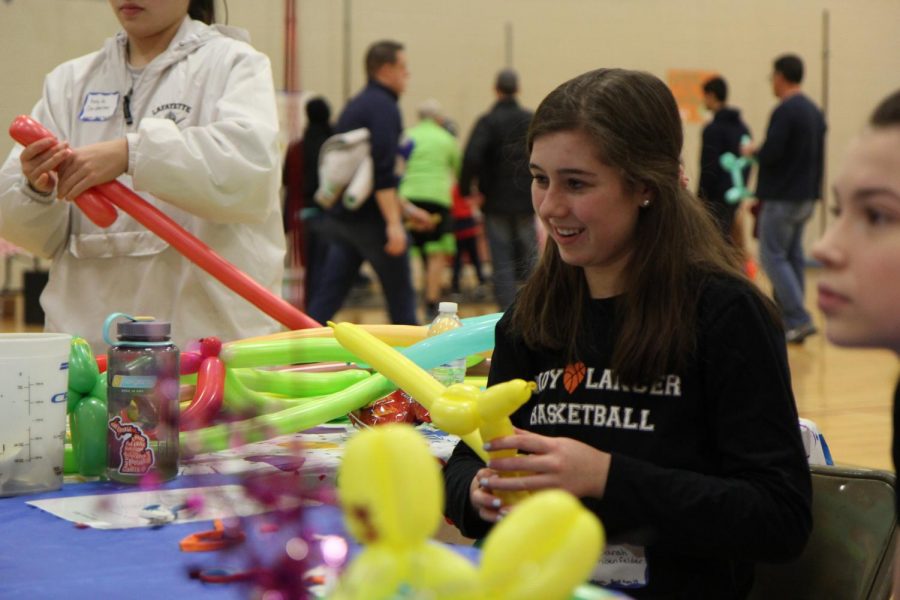 Sarah Schoenfelder, junior, blows balloon animals for children in the community. 