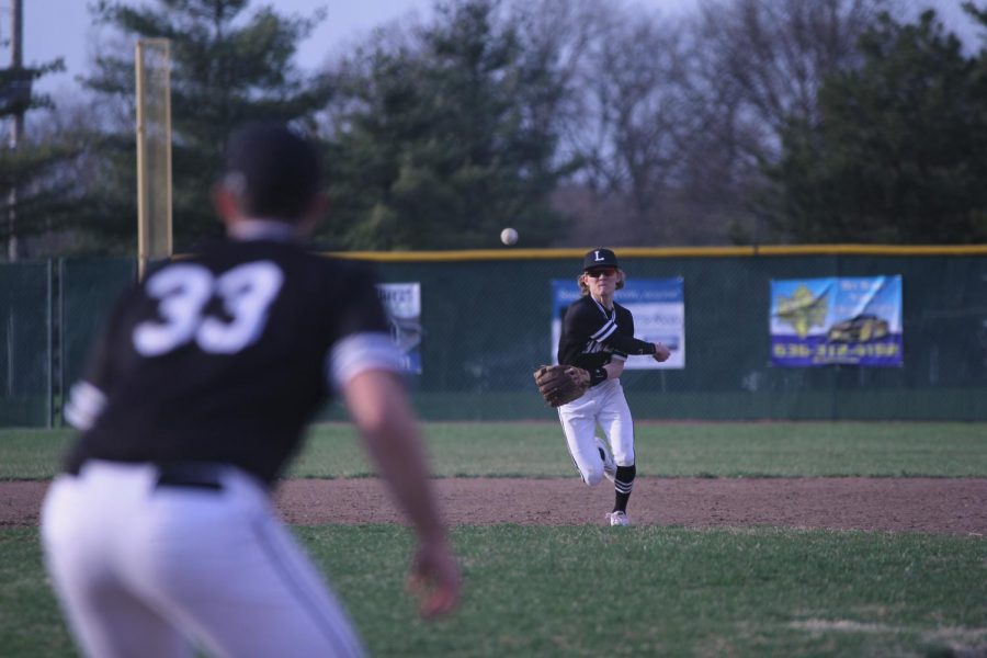 After fielding the ball, shortstop Ryan Neise throws the ball to first baseman Tyler Hagan.