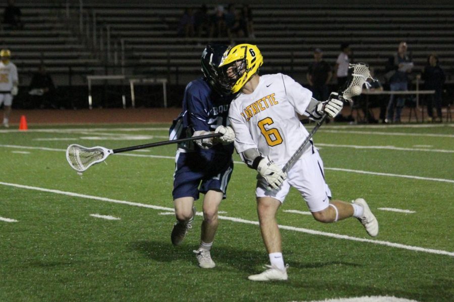 During the April 10 boys lacrosse game against Marquette, senior Jack Politte sprints past a Mustang defender. The Lancers fell to the Mustangs 9-8.