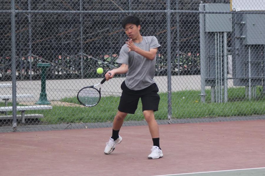 Returning a serve, freshman Merrick Zheng focus on the ball. Zheng was one of two freshmen on the varsity tennis team this year. 