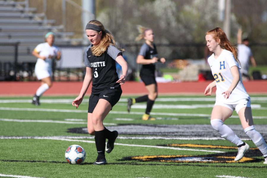 Dribbling down the field during the April 8 girls soccer game against Francis Howell, sophomore Brynn Jeffries avoids Viking defenders. Jeffries had one assist in the Lancers 3-1 win. 