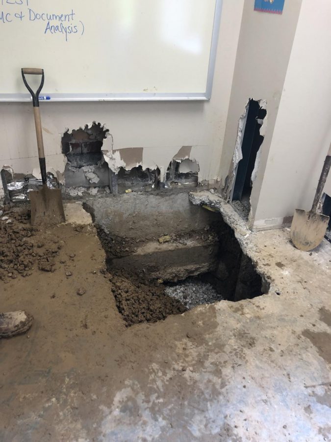 Holes in the floor and walls of Room 183 give workers access to the broken water main.