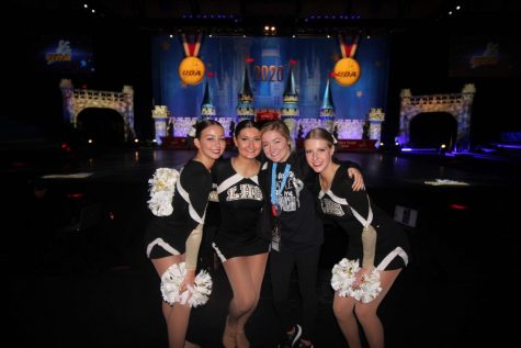 In Feb. 2020, Kennedy Willhite, Natalie Tuttle, coach April Ehrhardt and Leenie Johns all pose in front of the Cinderella Castle set up on the national stage. Johns, along with the rest of the team, traveled to Disney World from Jan. 29-Feb. 4 to compete in the National Dance Team Championship.