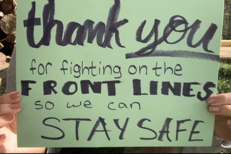 Sophomore Makayla Archambeault holds her sign up during her video submission for the Class of 2022's thank you video for front line workers.