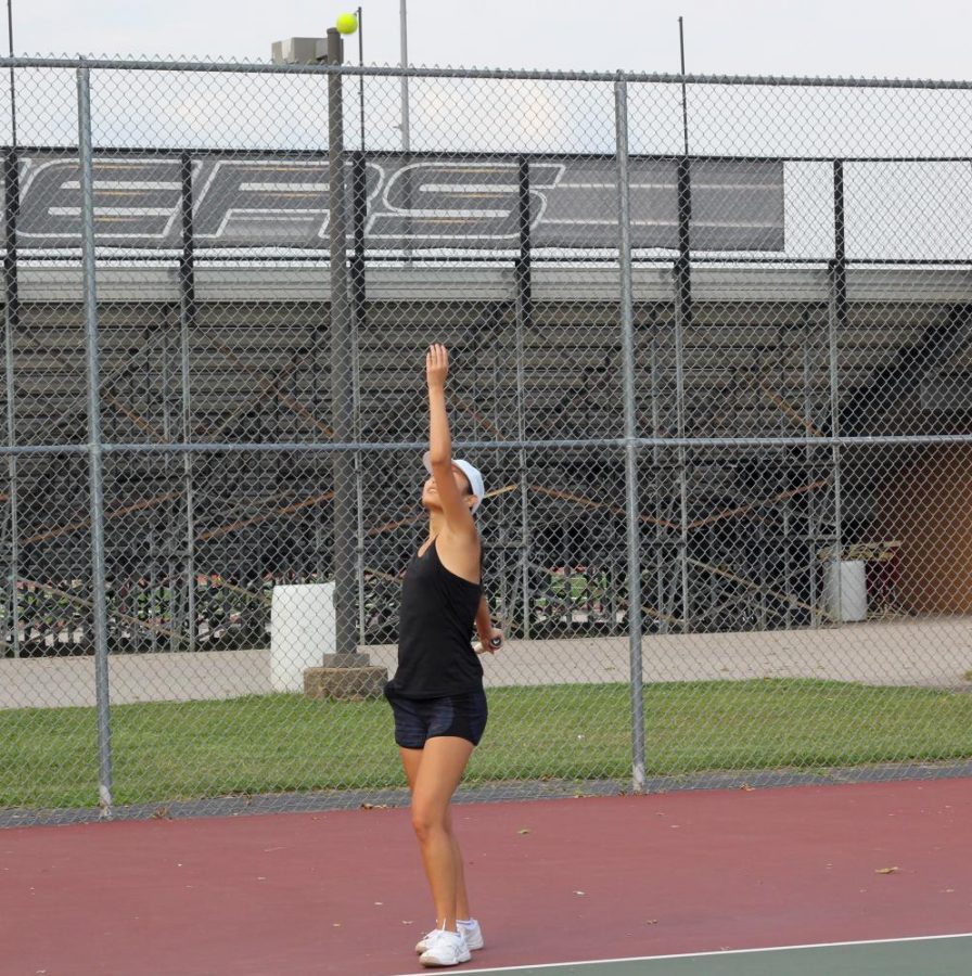Sophomore Audrey Tang tosses a the ball up to serve against an opponent during a practice earlier this month. Tennis is one of the low-contact sports that was among the first to be allowed to compete.
