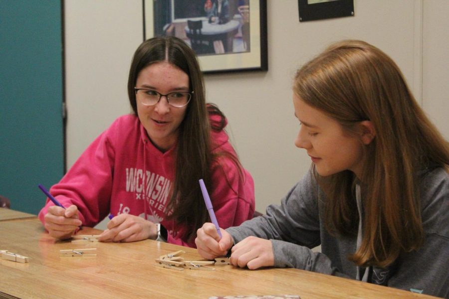 In November 2019, Lancers Helping Lancers organized and executed a mental health week. Seniors Sydney Stinnett and Taylor Wulf help to make clothespins to clip on to unsuspecting student's clothes and backpacks with uplifting messages written on them.