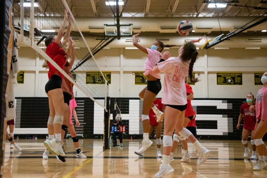 In a scrimmage against other team members, junior Paige Borgmeyer sets up to hit while her teammates attempt to block her. The volleyball team won began their season this week, winning matches against Incarnate Word and Francis Howell.