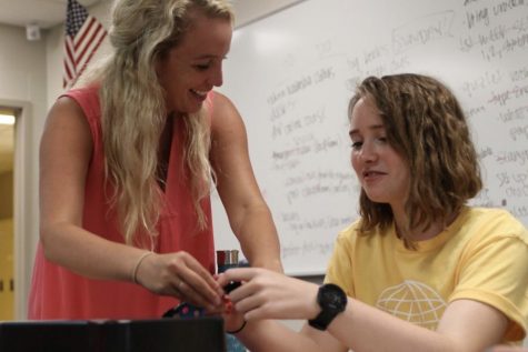 During former Latin teacher Emelia Osborne's Latin class, senior Brigid Ogle works on a breakout box project with the help of Osborne.