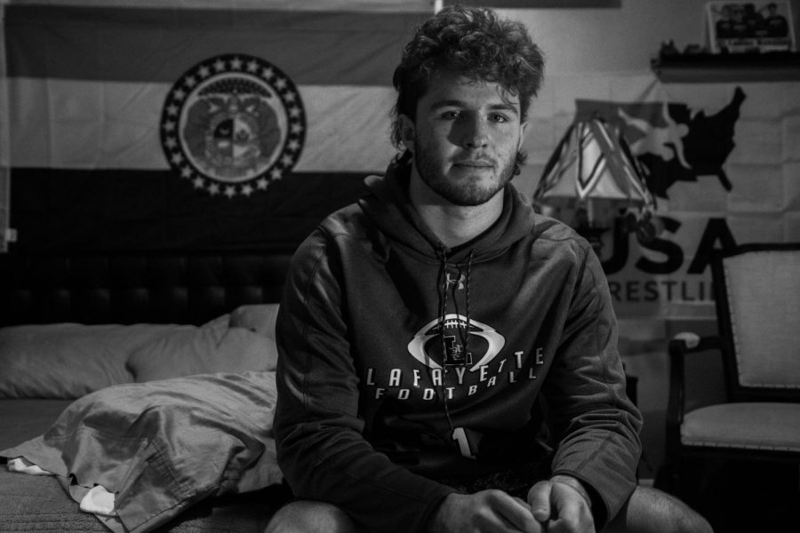 Tommy Hagan sits in his isolation room, where he stayed after testing positive for coronavirus. For meals he said, I mostly snacked. Hagan has since recovered from the virus and is now participating in football and other activities. 