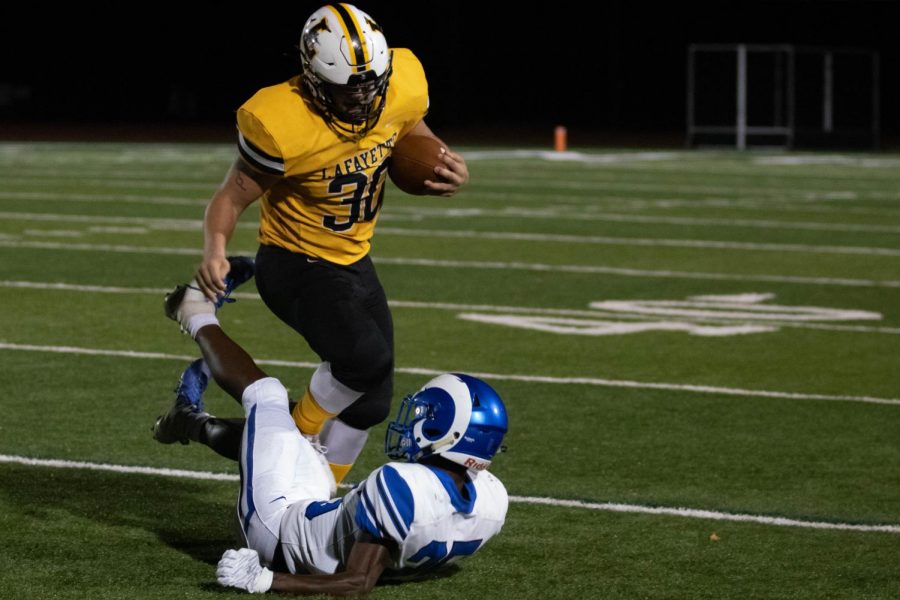 In a game against Ladue High School, senior Mitchel Hoffman runs over a defender. The Lancers won the game 44-38, and Hoffman had 138 rushing yards.