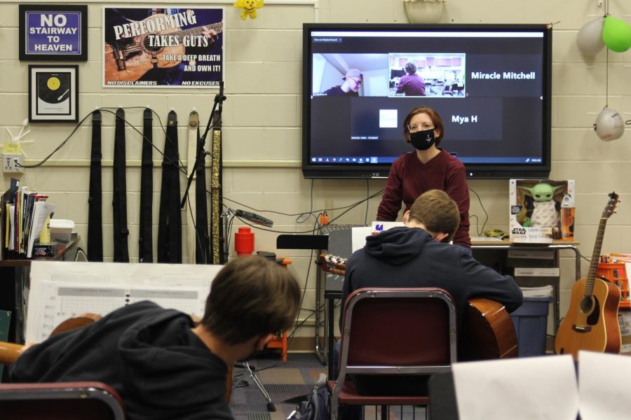 Guitar teacher Traci Bolton simultaneously instructs her in-person students and her online learners during her 4th Hour guitar ensemble class. Unlike in this picture, virtual  students next year will be asynchronous.