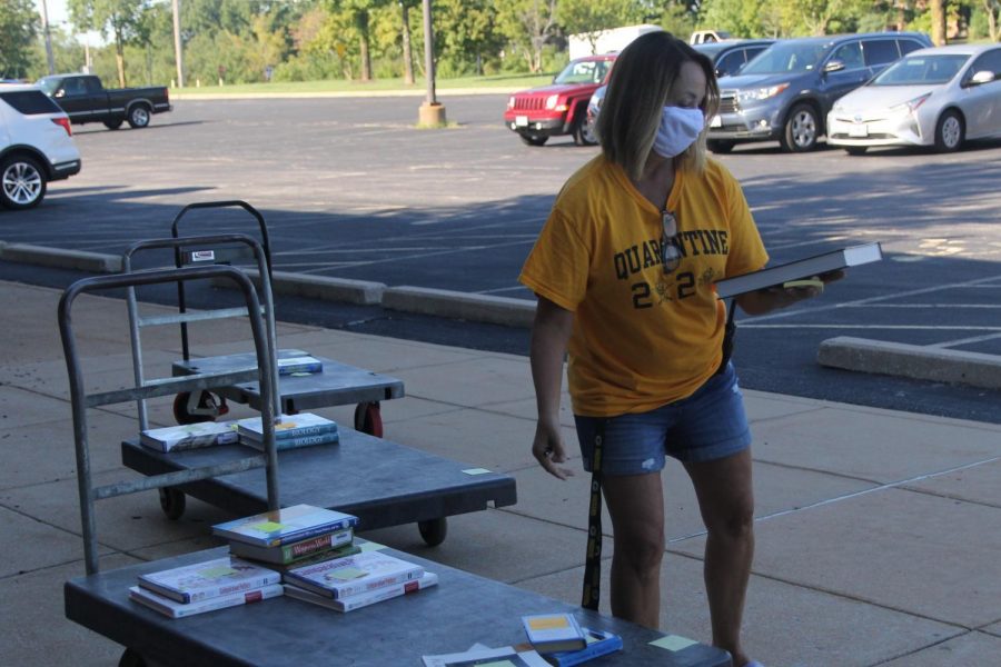 Class secretary Karen Barber helps distribute books and materials during the August 2020 date for Chromebook drop-off and material pick-up.