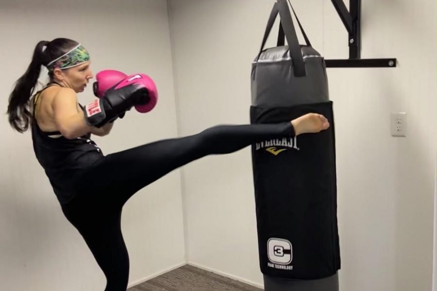 Lori Dziewa performs a high kick on a punching bag as part of her training. Dziewa trains six times per week in boxing/kickboxing. She also does cardio exercises two of those same days per week. 