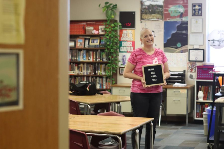 Language arts teacher Jenny Ingram stands in her classroom holding her "Good Vibes Only" sign. In June 2021 Ingram learned that her Breast Cancer resurfaced as Stage Four. She has since made an effort to maintain a positive perspective.