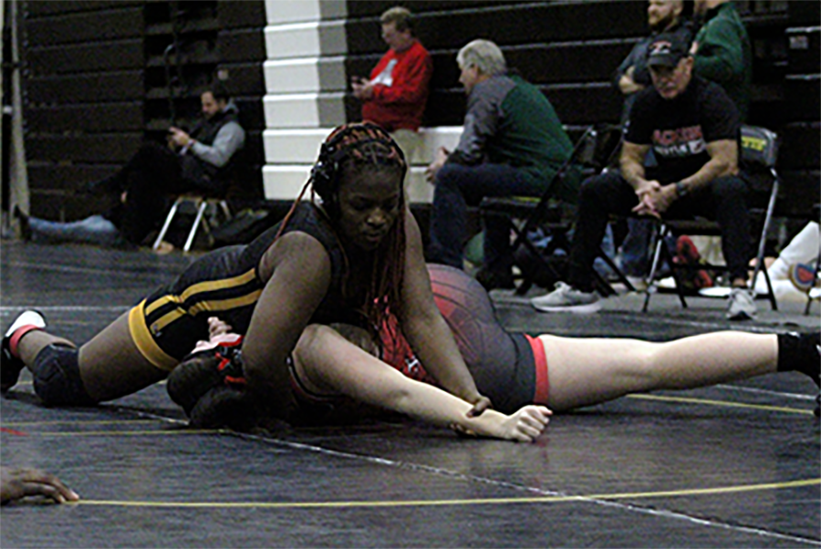 At the Fred Ross Invitational, junior Jayla Jones looks to pin her opponent from Jackson High School. Jones placed first in her weight class in the tournament, contributing to the teams third place overall  finish.