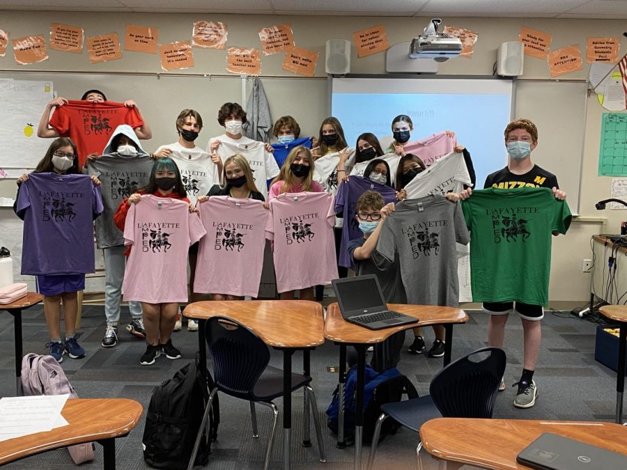 Freshman AMPED class showing off their fresh t-shirts they have just learned how to press.