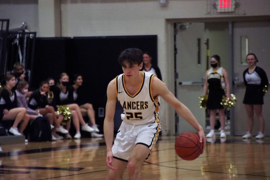 Junior Josh Dennis dribbles the ball during the Lancers game against the Lindbergh Flyers on Jan. 18. Dennis scored four points and had two rebounds. 