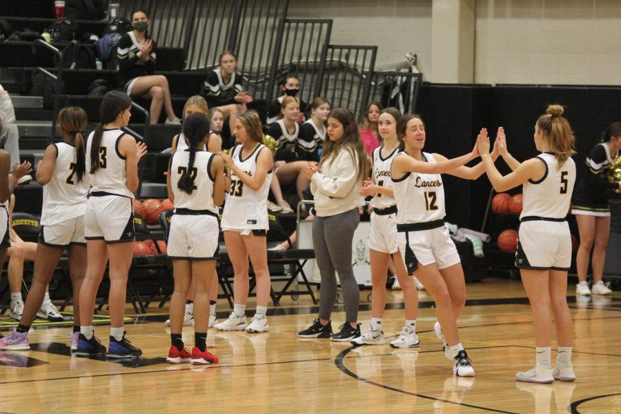 Senior Lily Zehner (right) celebrates with freshman Aubrey Sinn (far right)  after scoring in the Lady Lancers game against the Ladue Rams. Zehner scored six points during the game along with being two for two in free throw opportunities.