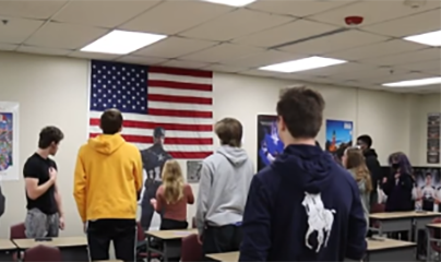 Members of the 1st Hour ROTC class stand for the Pledge of Allegiance as it is read over the intercom for the school.