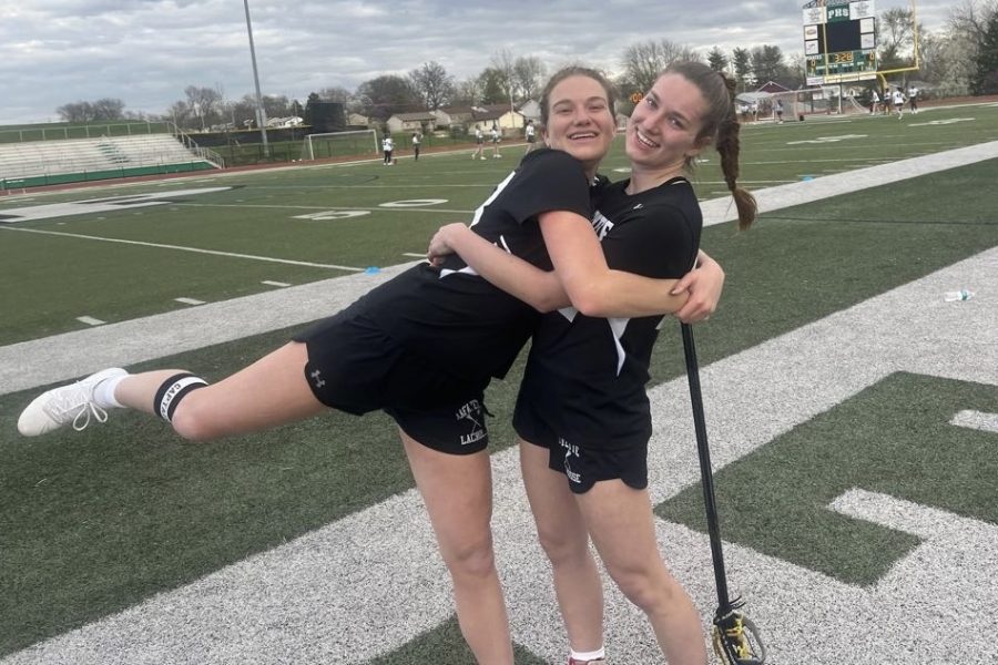 Sisters Ansley (left) and Mary (right) Hails pose for a photo before their game against Pattonville High School, where they won 16-7. During the game, senior captain Ansley scored two goals and both Ansley and Mary won two ground balls. The sisters also chose sister numbers for their jerseys, with Mary choosing 22 and Ansley choosing 23. 