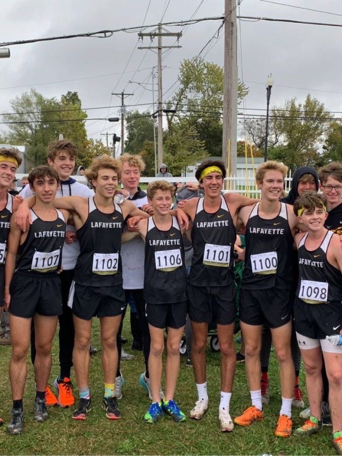 Senior Andrew Domsalla (second to right) smiles with the varsity cross country team.