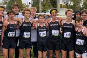 Senior Andrew Domsalla (second to right) smiles with the varsity cross country team.