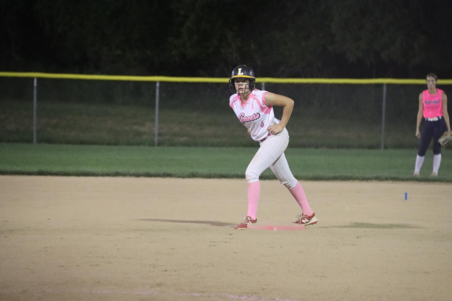 On the field, junior Addyson Jones prepares to run to the next base at the annual Pink Game against Marquette on September 20. The team beat the Mustangs 11-7.