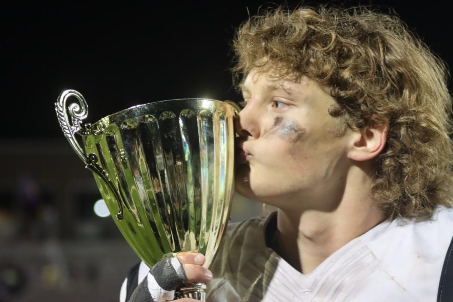 At the end of the game, senior Kris Kamrud kisses the Mayors Cup. Kamrud had 7 tackles during the game.