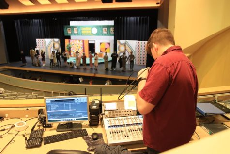 At a dress rehearsal for the Spring Musical 9 to 5 on Feb. 6, sophomore Michael Niblett, lights lead, works in the sound booth while the actors line up for mic check. The show will run from Feb. 9-11.