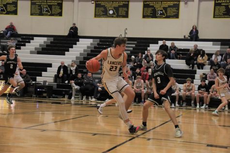 Senior Matt Haefner stops mid court in the game against Mehlville as the defense moves in. In this game, he scored his 1,000th career point as the Lancers moved to 13-12 for the season.